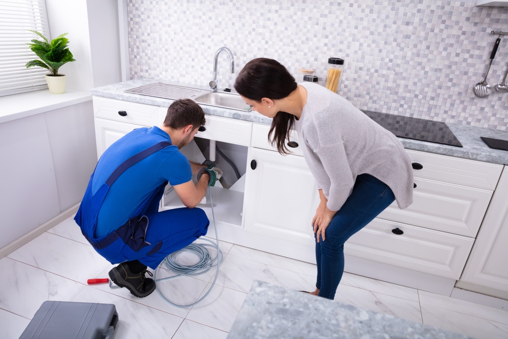 A plumber fixing a leaky faucet.